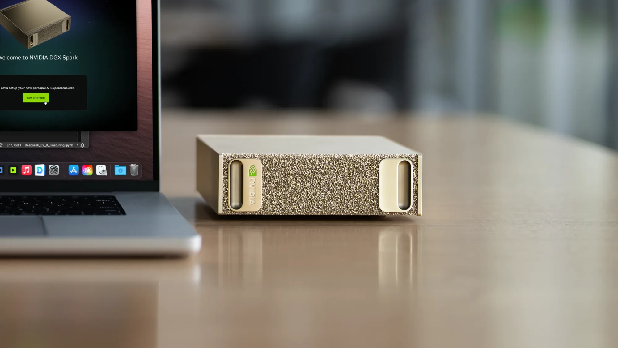 An NVIDIA DGX Spark on a wooden desk beside a laptop showing its setup screen
